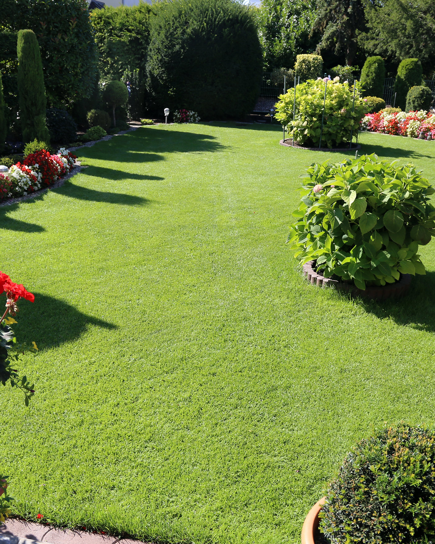Gepflegter Garten mit Rasen und Blumenbeeten, betreut von Hausmeister Service Schwartz